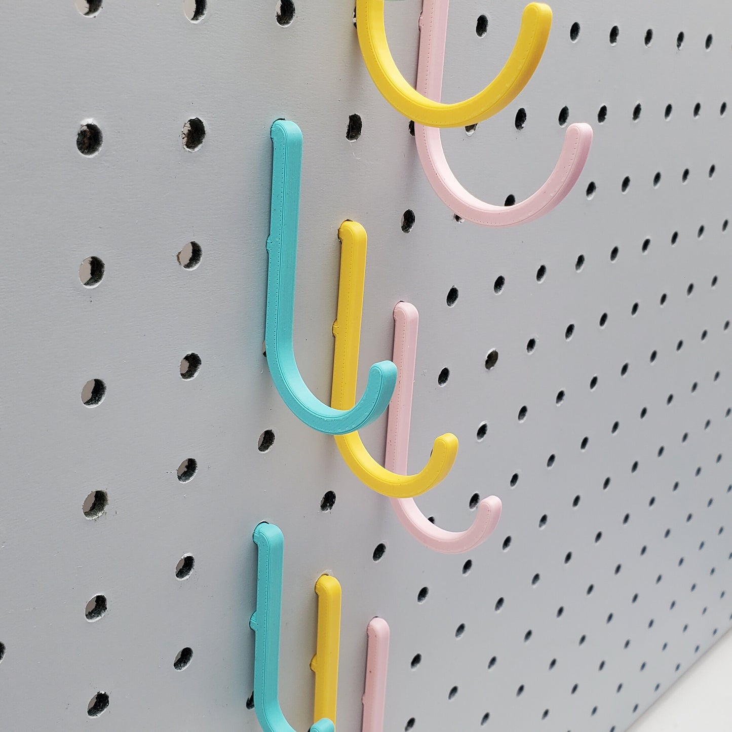 Light Pink, Teal, and Savannah Yellow J-Hooks for 1/4" Pegboards. Displaying Medium Size