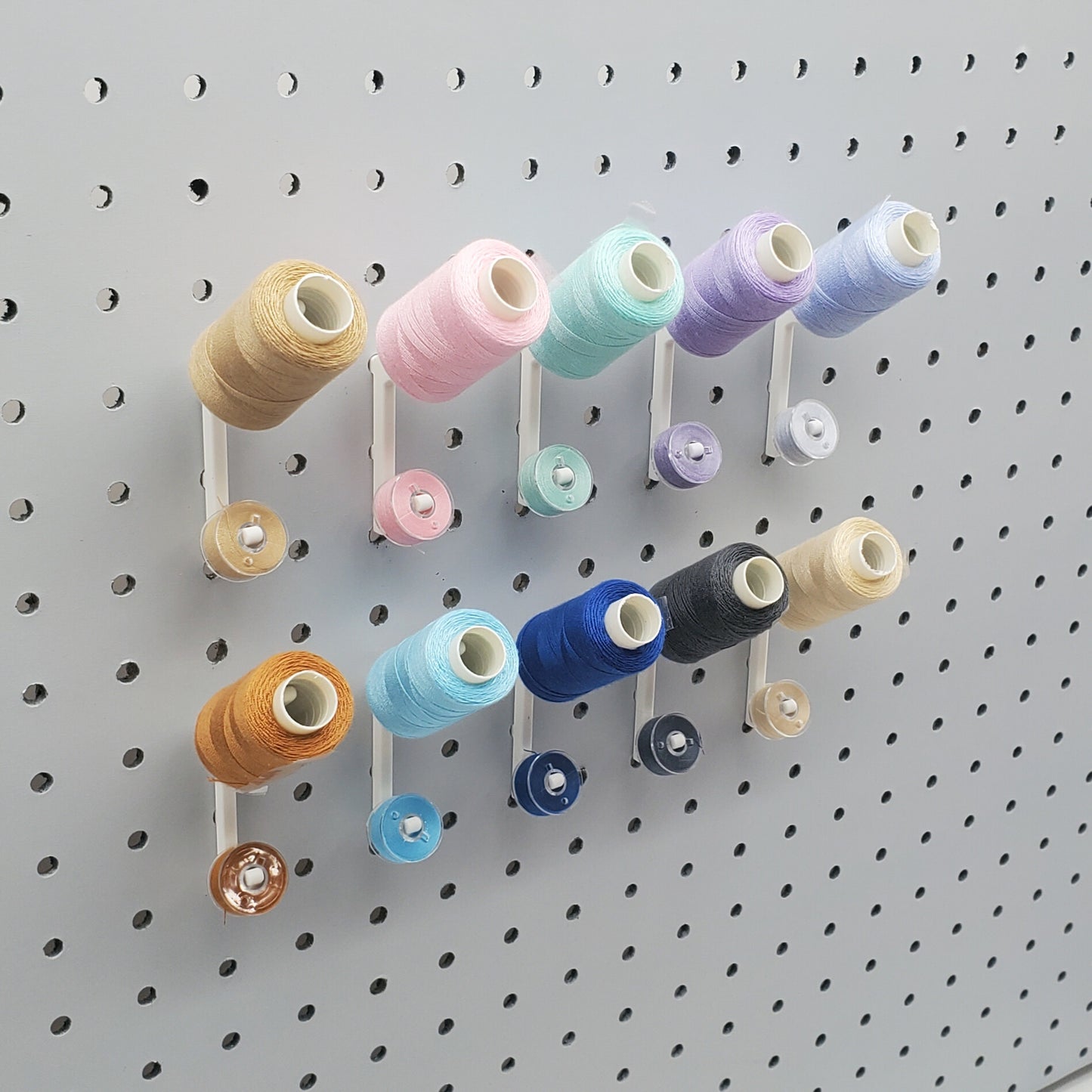 10 Cotton White Flat Thread-Bobbin on a 1/4" Pegboard.