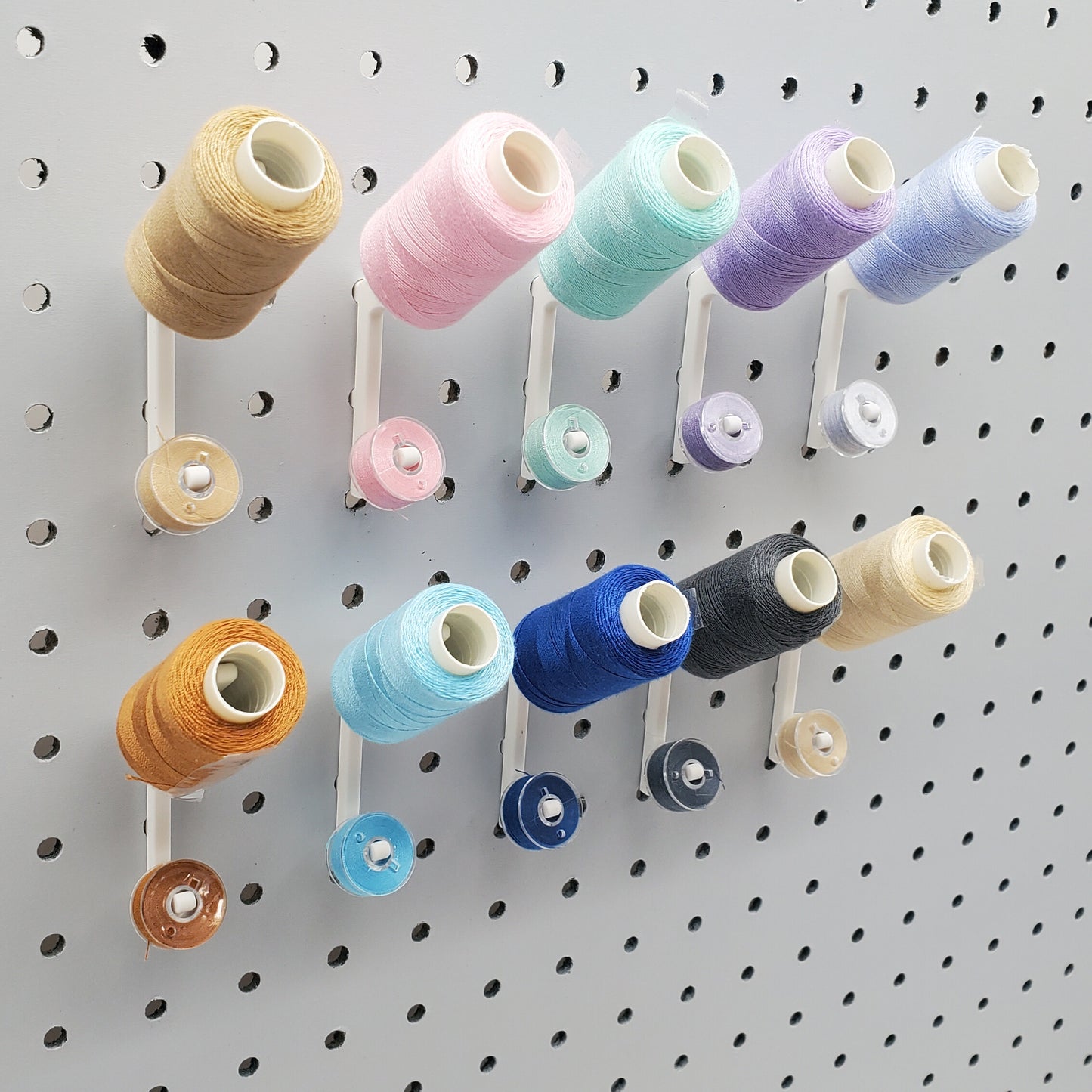 10 Cotton White Flat Thread-Bobbin on a 1/4" Pegboard.