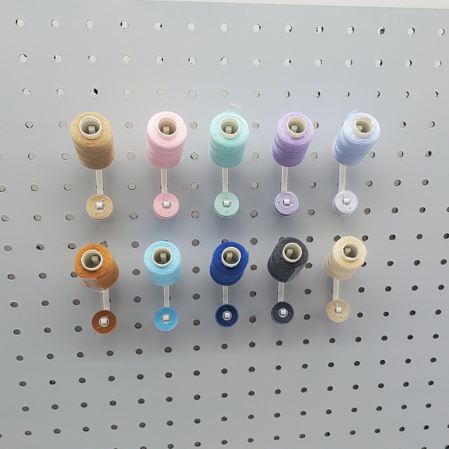 10 Cotton White Flat Thread-Bobbin on a 1/4" Pegboard.