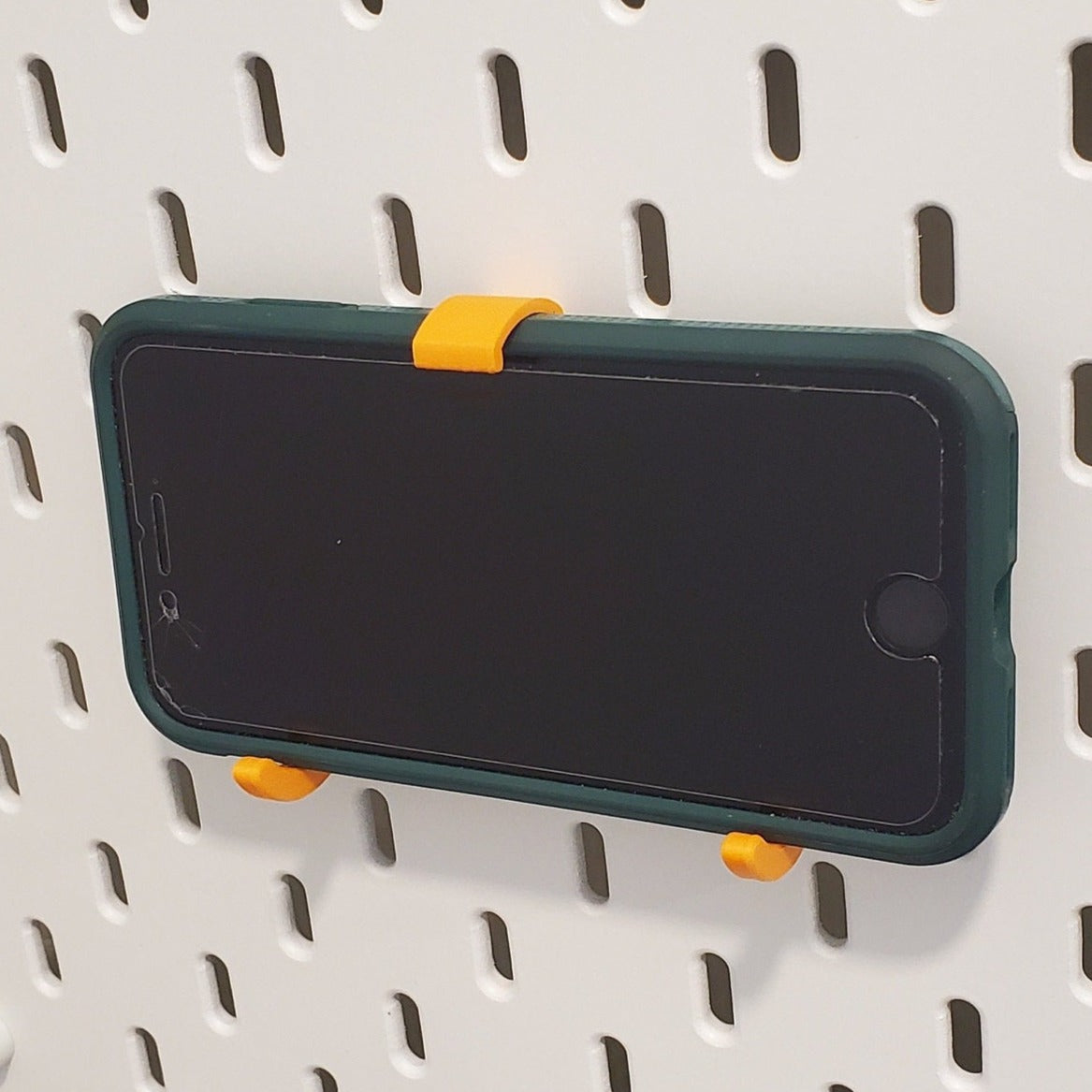 Ikea SKADIS Tablet Holder holding an iPhone