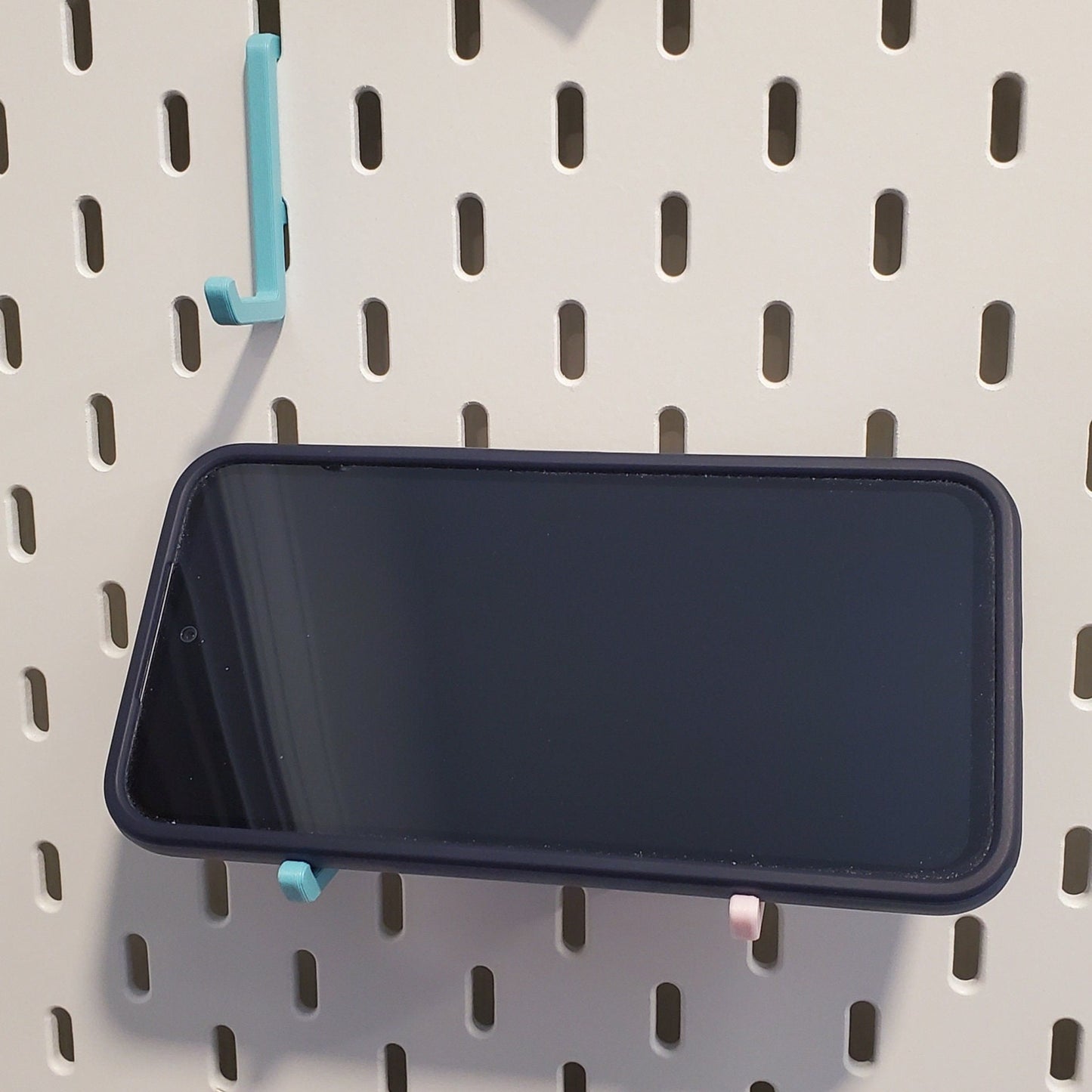 Two Large L-Hooks supporting phone on an IKEA SKADIS Pegboard