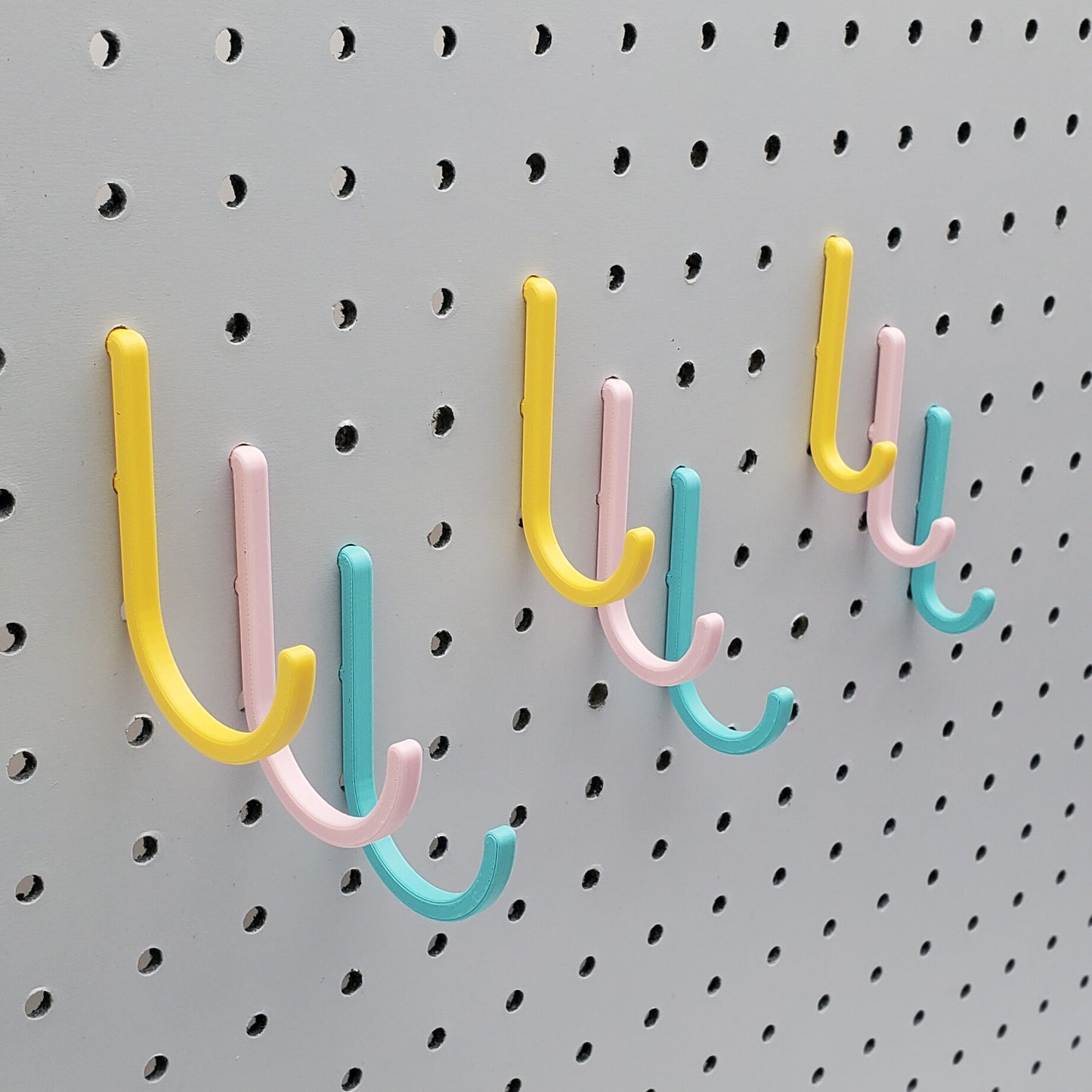 Light Pink, Teal, and Savannah Yellow J-Hooks for 1/4" Pegboards. Displaying all three sizes.