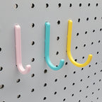 Small, Medium, and Large J Hooks in Light Pink, Teal, and Savannah Yellow on 1/4" pegboard.