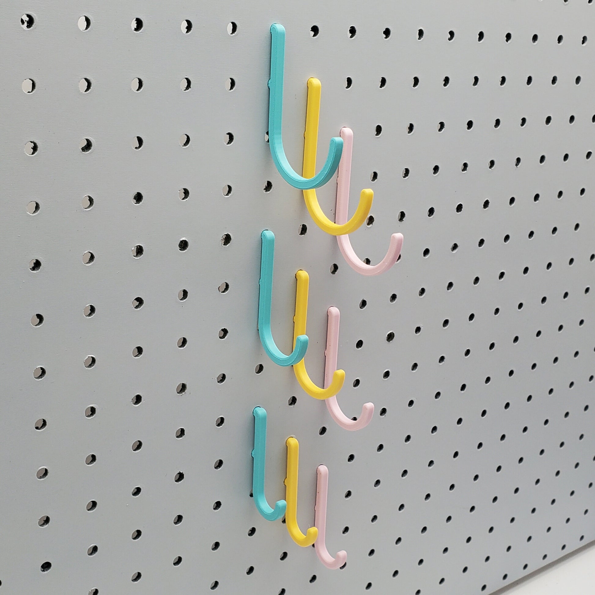 Light Pink, Teal, and Savannah Yellow J-Hooks for 1/4" Pegboards. Displaying all three sizes.