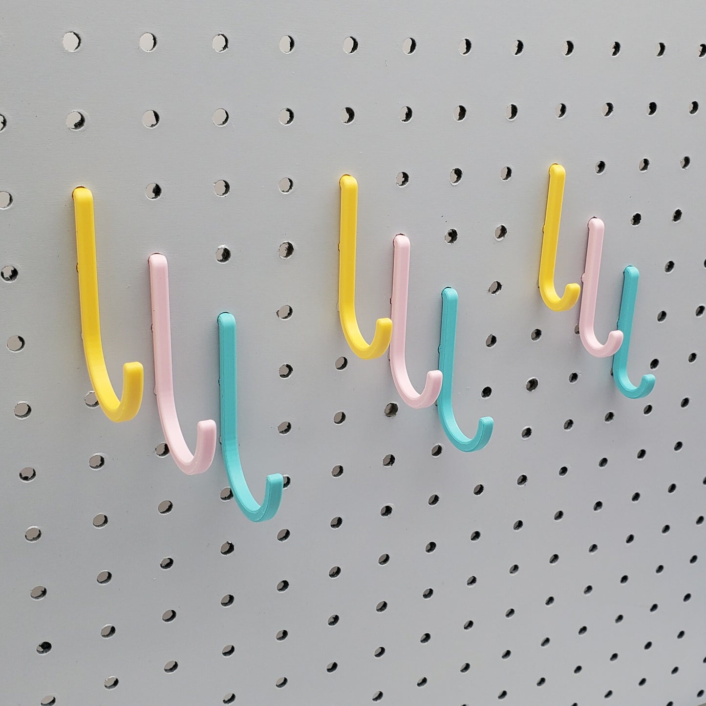 Light Pink, Teal, and Savannah Yellow J-Hooks for 1/4" Pegboards. Displaying all three sizes.