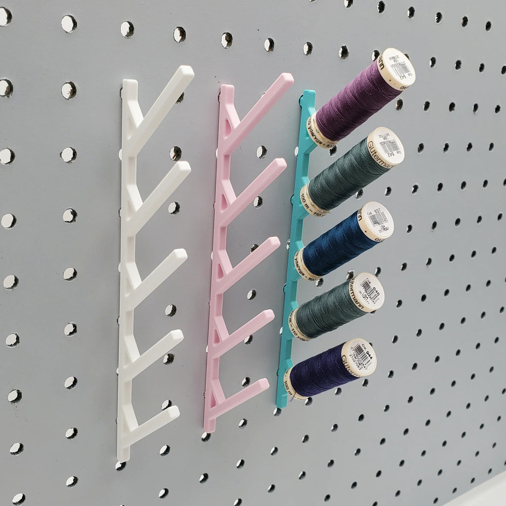 Three Small Thread Racks in Cotton White, Light Pink, and Teal on 1/4" pegboard with thread.
