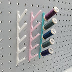 Three Small Thread Racks in Cotton White, Light Pink, and Teal on 1/4" pegboard with thread.