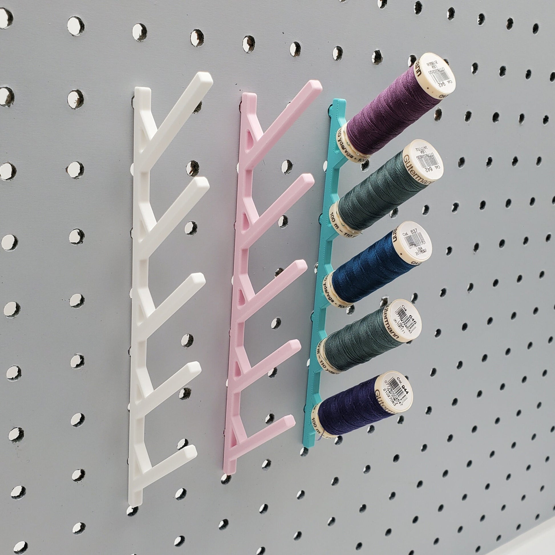Three Small Thread Racks in Cotton White, Light Pink, and Teal on 1/4" pegboard with thread.