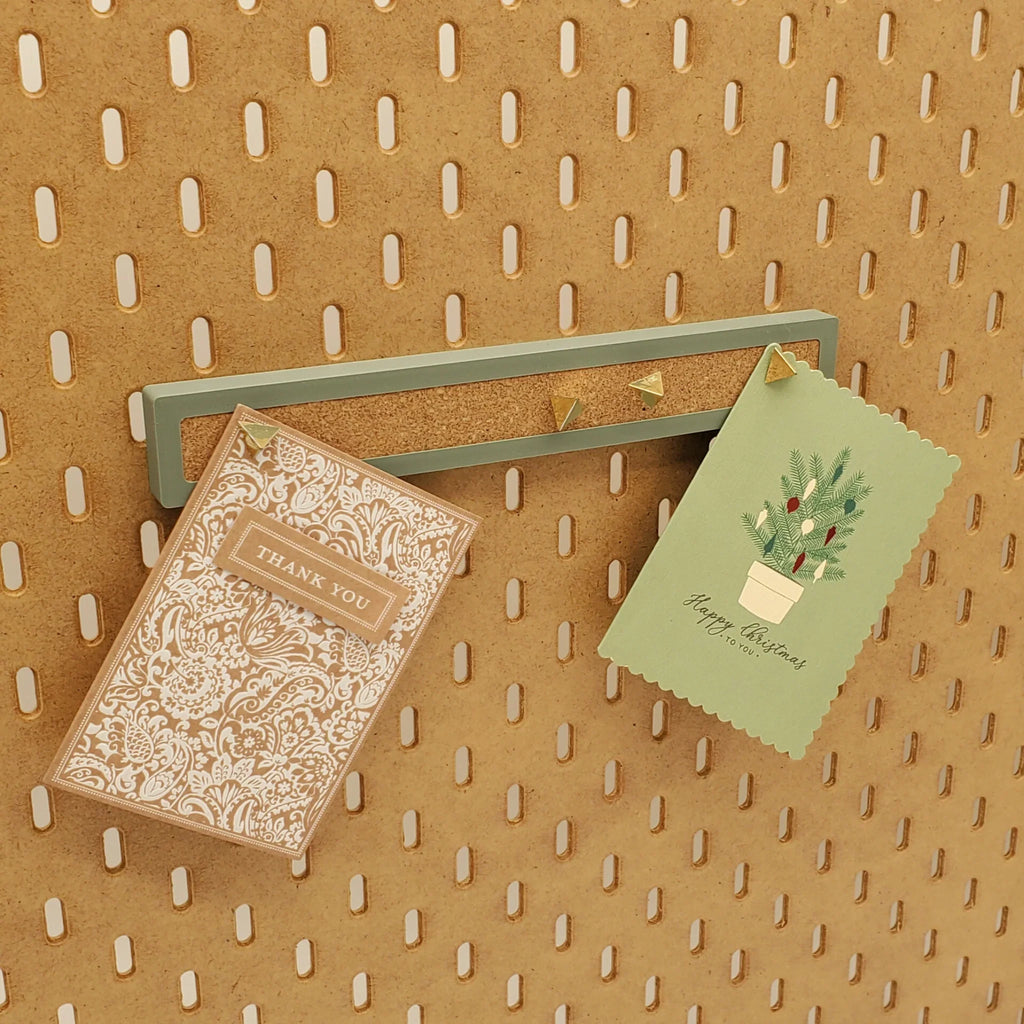 Large Corkboard Strip in Muted Green on IKEA SKADIS pegboard with pins and notes.