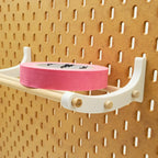 Detail view of Tape Shelf Brackets in Cotton White on IKEA SKADIS pegboard.