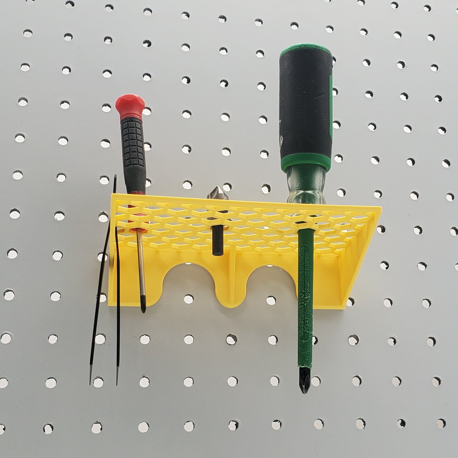 Under side of yellow screwdriver holder on a pegboard
