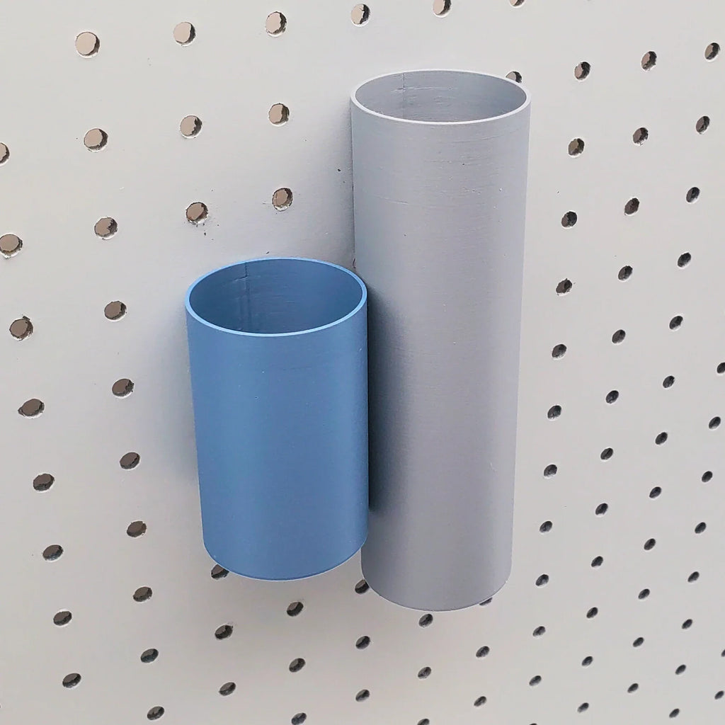 Large Cylinder Pen Tube in Fossil Gray next to Small Cylinder Pen Tube in Muted Blue on 1/4" Pegboard.