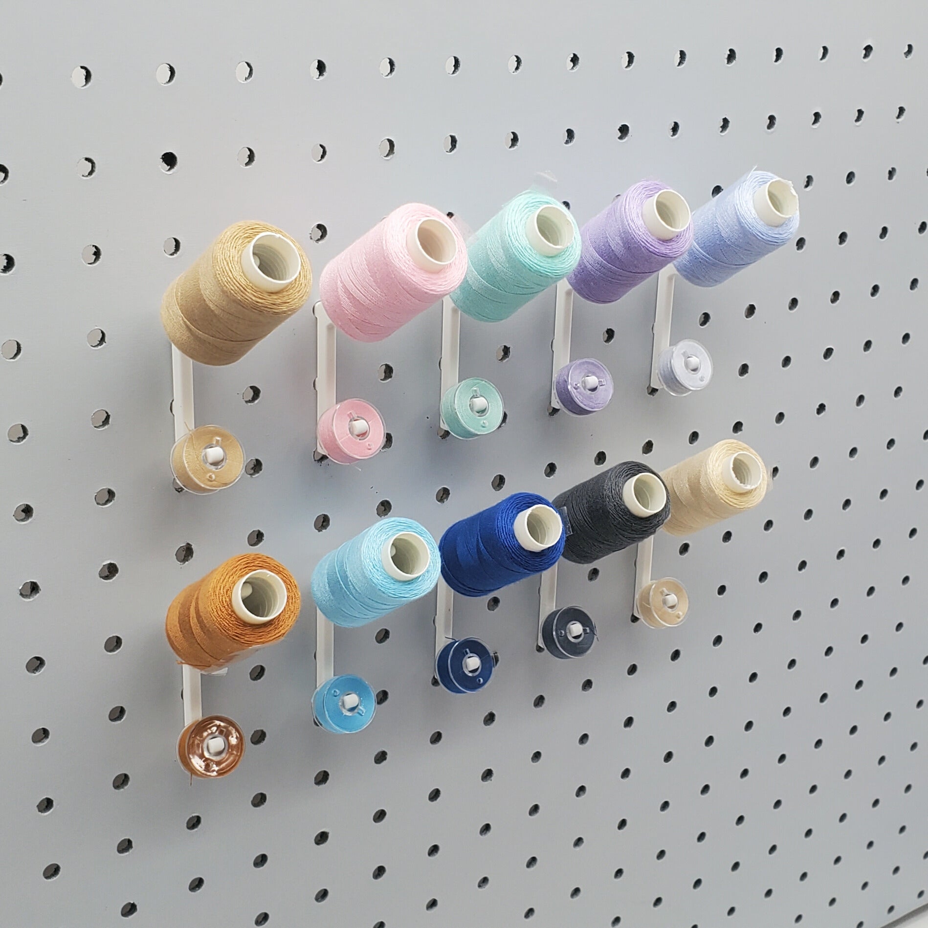 10 Cotton White Flat Thread-Bobbin on a 1/4" Pegboard.