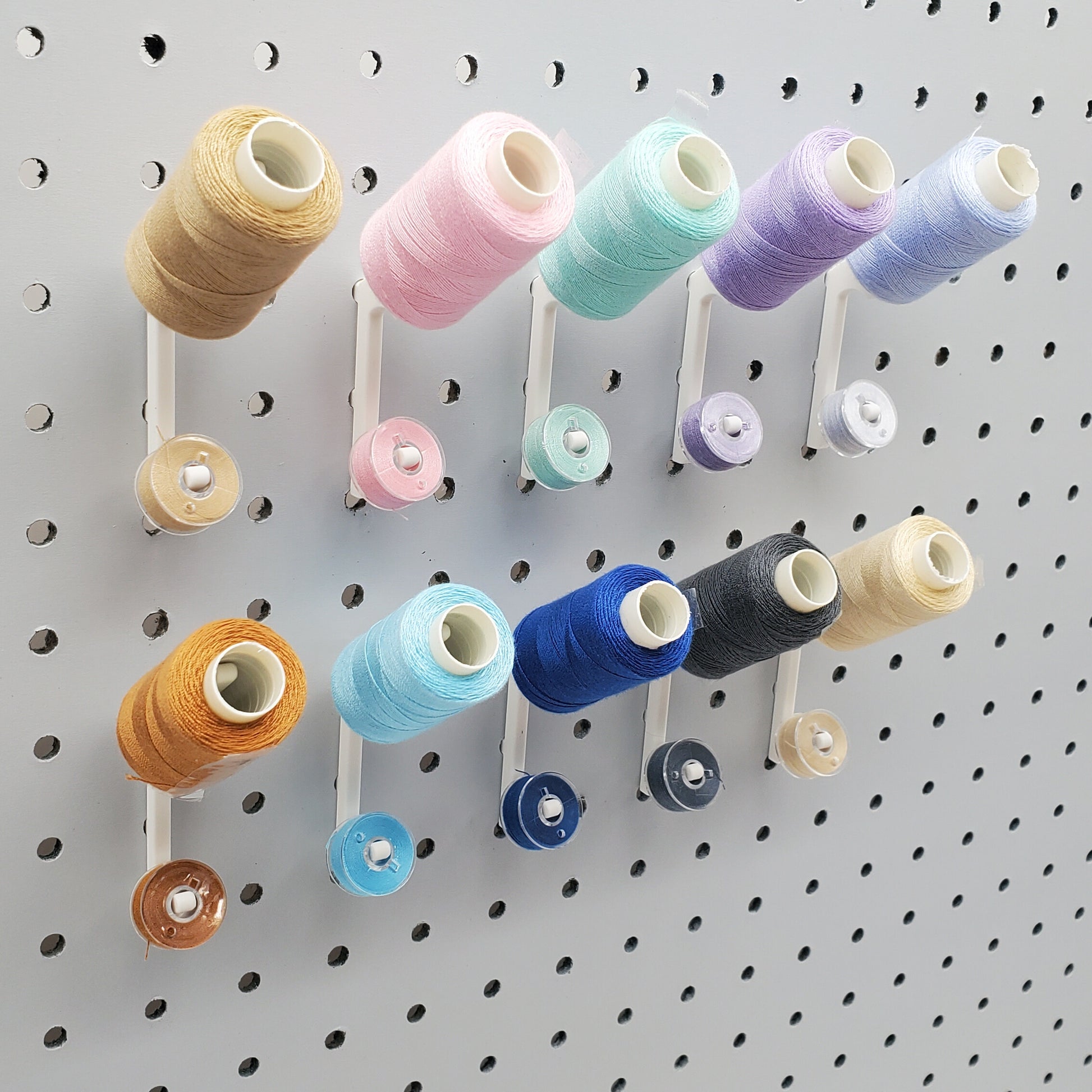 10 Cotton White Flat Thread-Bobbin on a 1/4" Pegboard.