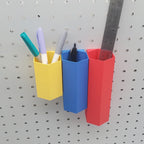 Small Hexagon Pen Tube in Savannah Yellow, Medium Hexagon Pen Tube in Sapphire Blue, and Large Pen Tube in Lava Red on 1/4" pegboard with markers and a ruler.