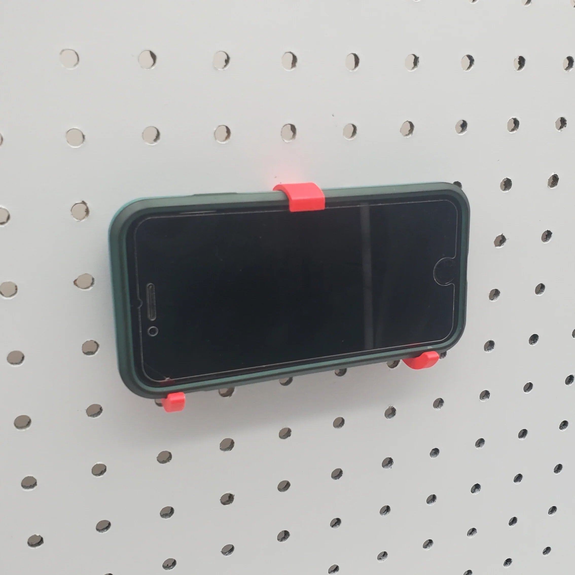 iPhone and Tablet Holder in Lava Red on 1/4" pegboard with iPhone.