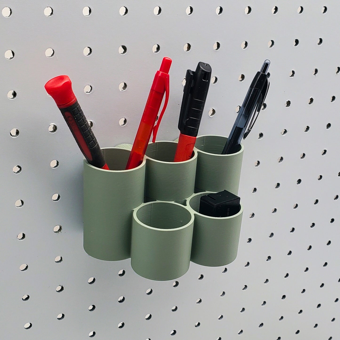 Tiered Pen & Pencil Organizer in Muted Green on 1/4" pegboard with pens and pencils.