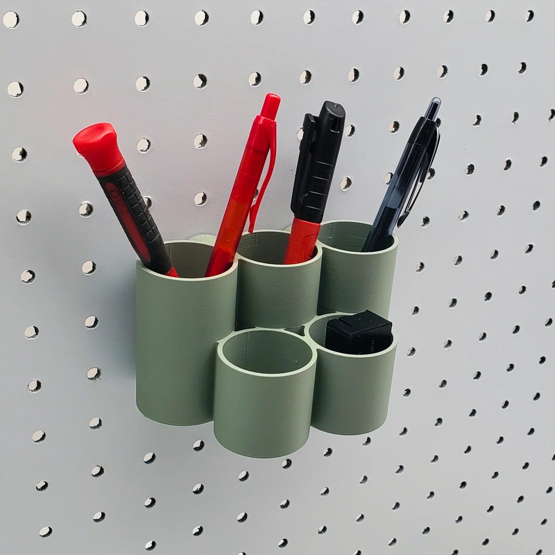 Cylinder Tiered Pen & Pencil Organizer in Muted Green on 1/4" Pegboard with writing utensils.
