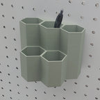 Tall Hexagon Tiered Pen and Pencil Organizer in Muted Green on 1/4" Pegboard with pen.