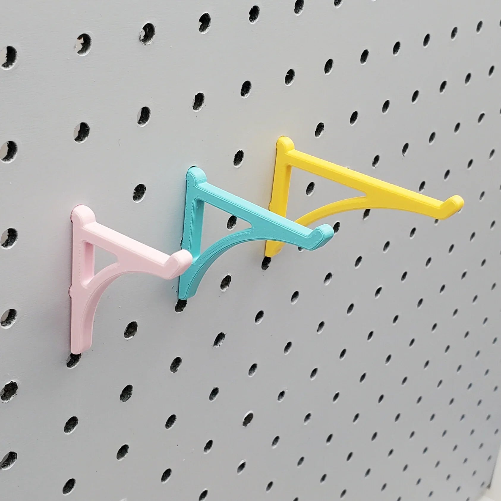 Small, Medium, and Large Platform Hooks in Light Pink, Teal, and Savannah Yellow on 1/4" pegboard.