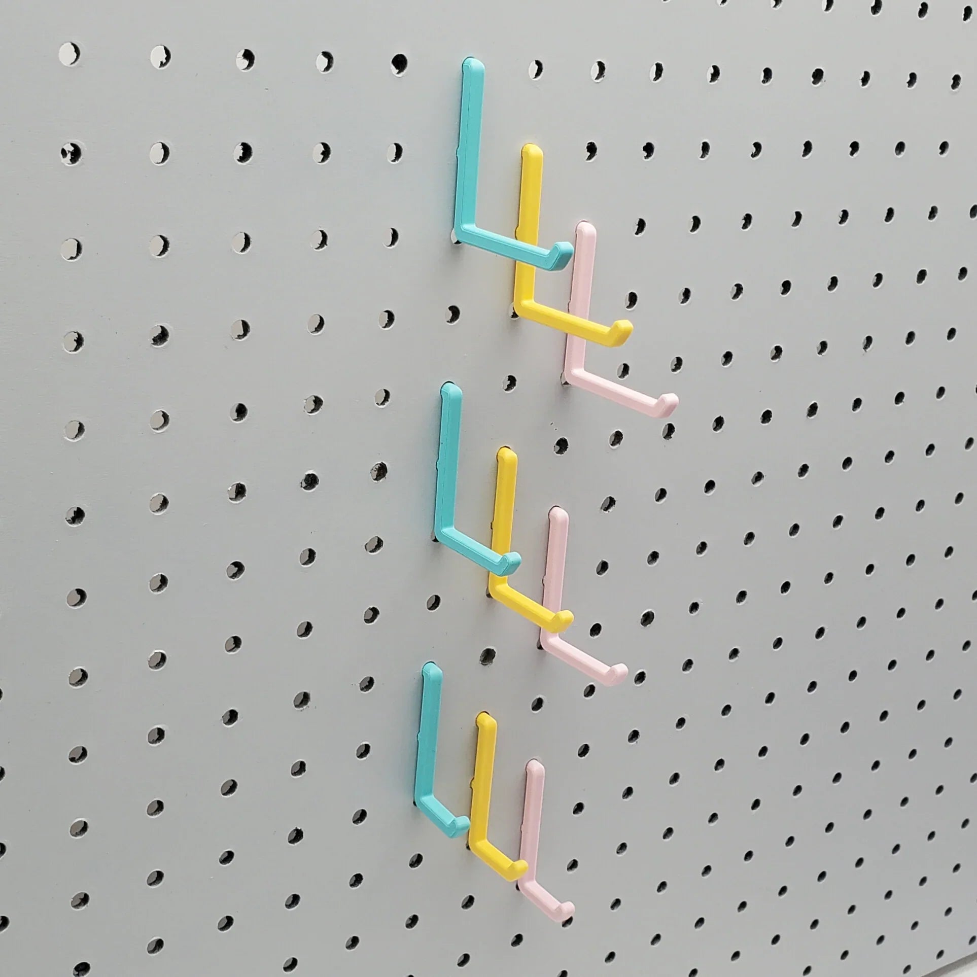 Small, Medium, and Large L Hooks in Light Pink, Teal and Savannah Yellow on 1/4" Pegboard.