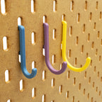 Small, Medium, and Large J Hooks in Muted Blue, Muted Purple, and Savannah Yellow on IKEA SKADIS pegboard.