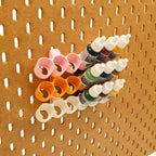 Tilted Model Paint rack in Cotton White, Sunrise Orange, and Light Pink on IKEA SKADIS pegboard with colorful Model Paints.