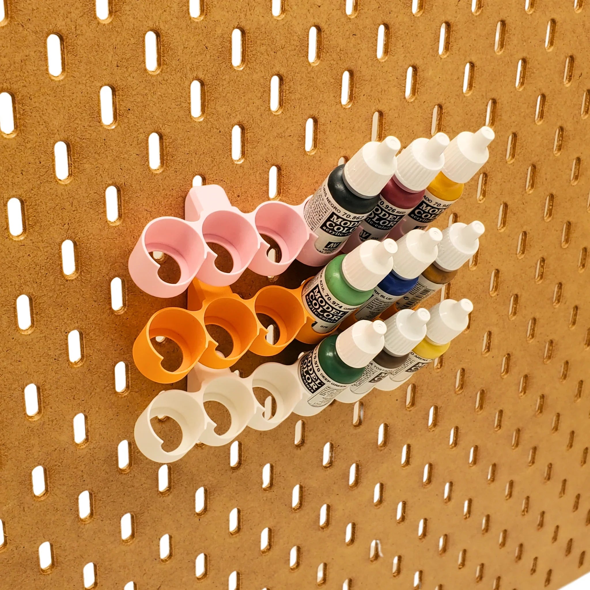 Tilted Model Paint rack in Cotton White, Sunrise Orange, and Light Pink on IKEA SKADIS pegboard with colorful Model Paints.