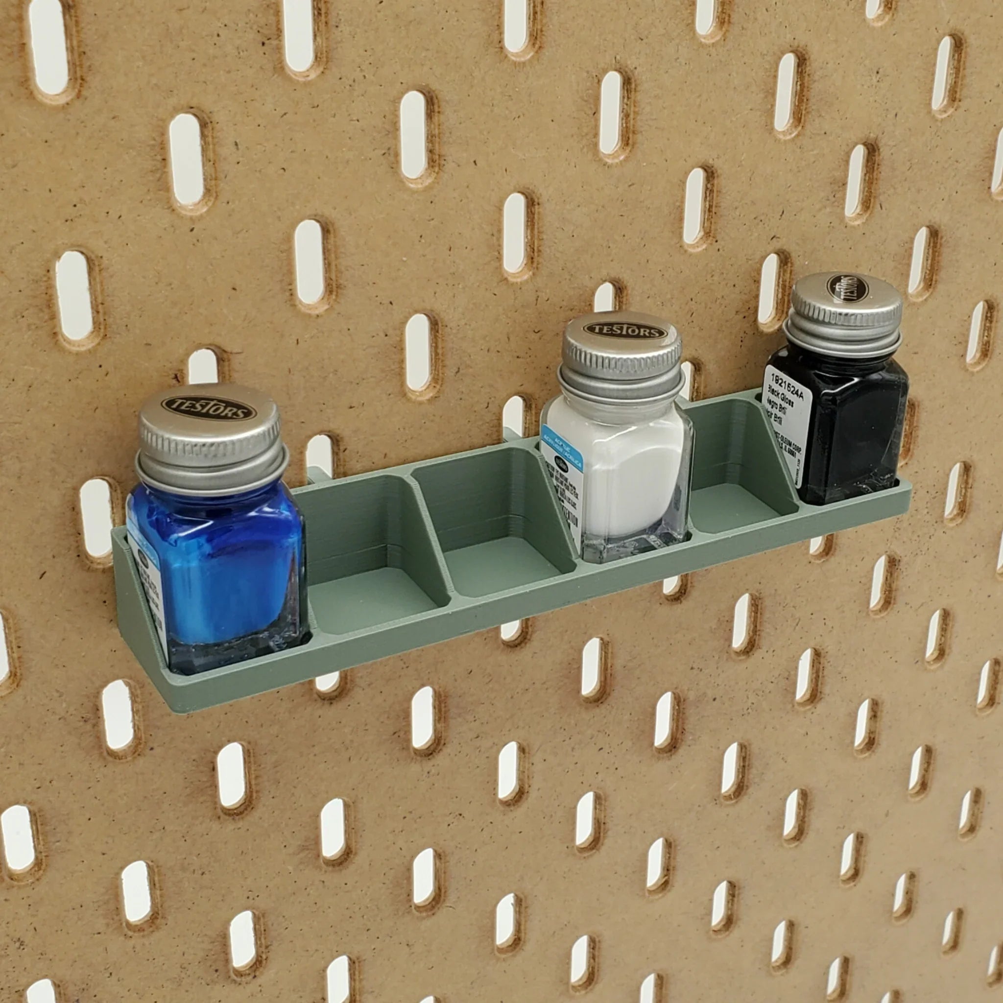 Testors Paint Rack in Muted Green on IKEA SKADIS pegboard with blue, white, and black paint.
