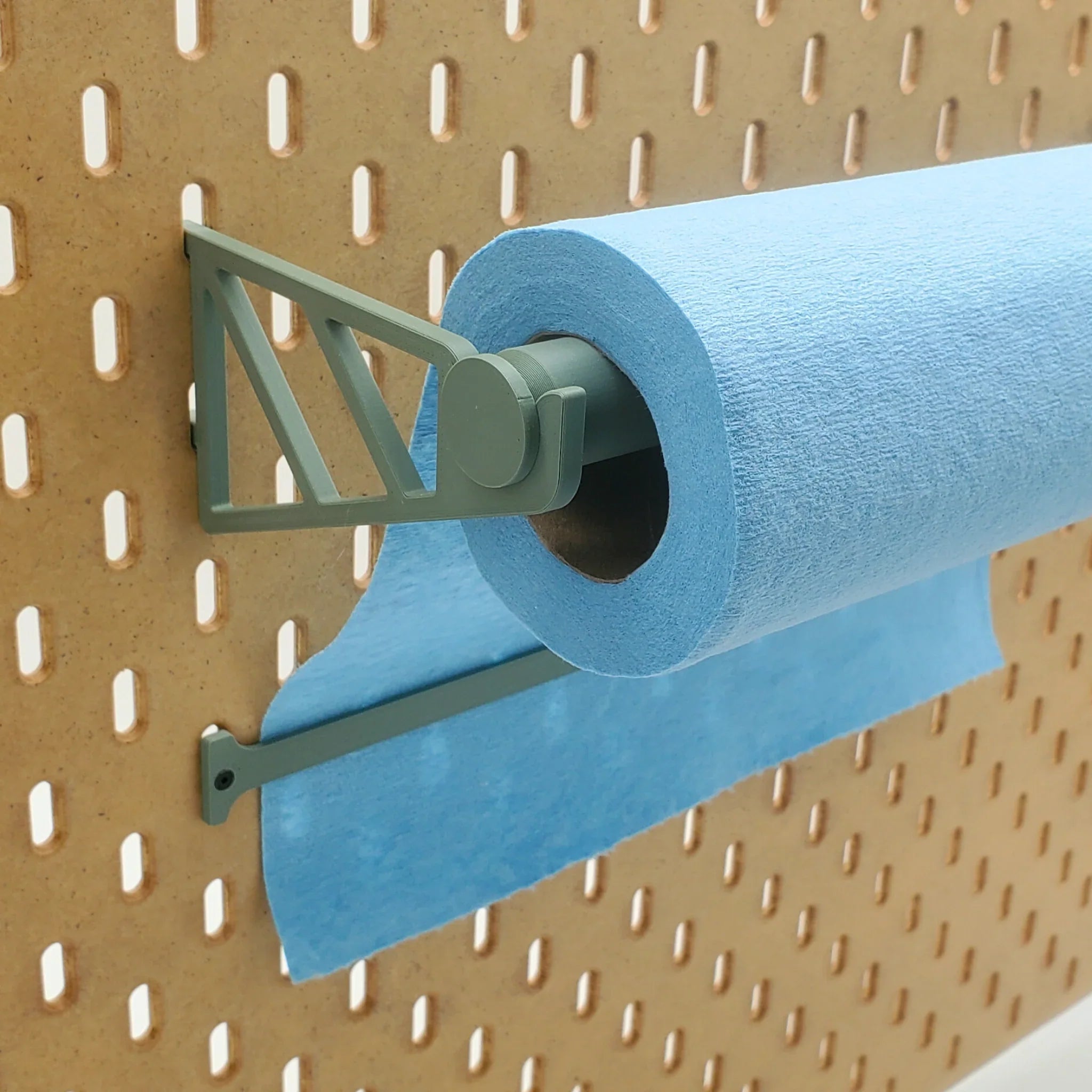 Paper Towel Holder with Tear-Off Bar in Muted Green on IKEA SKADIS pegboard with blue shop towels.